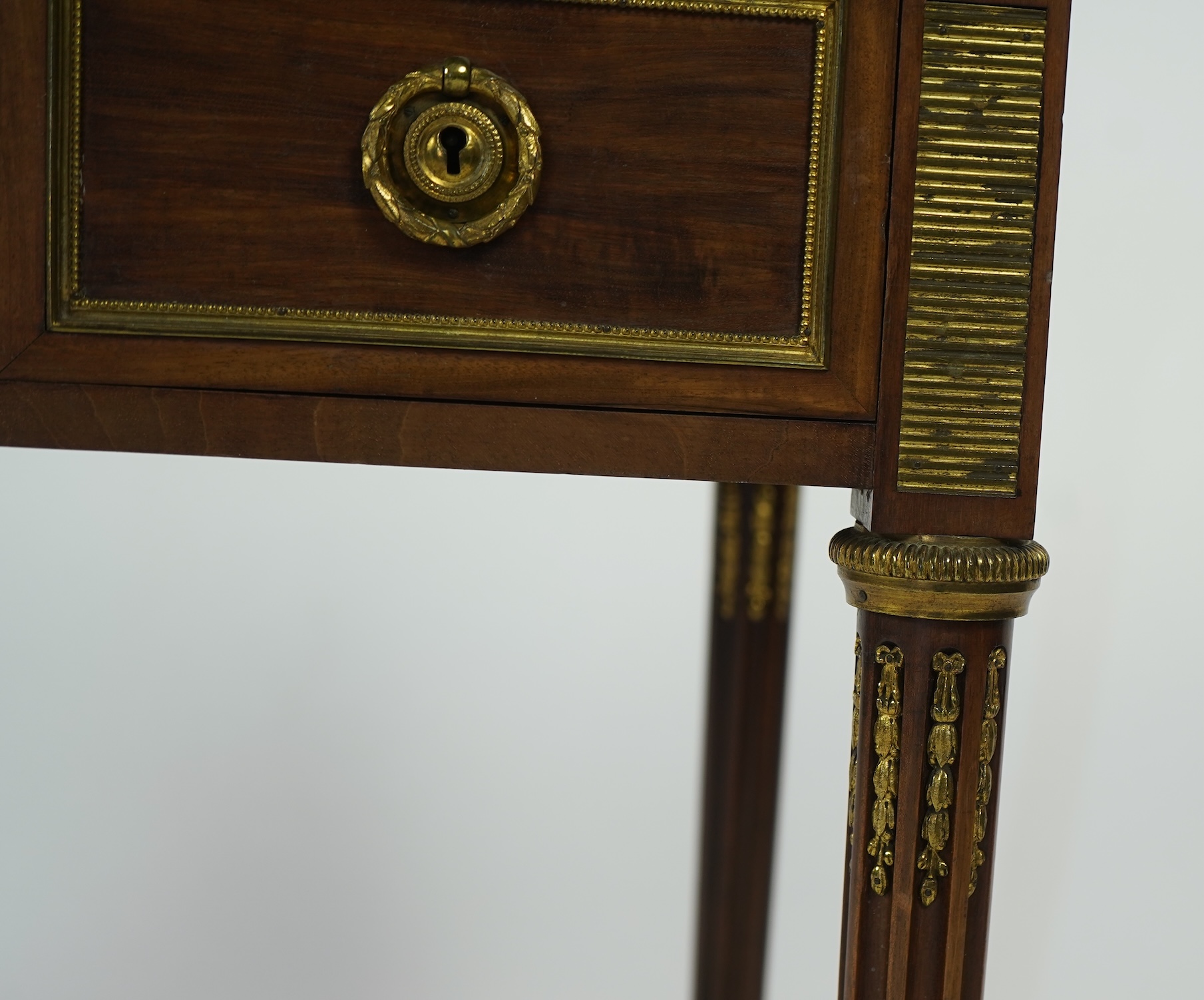 An early 20th century Louis XVI style brass mounted mahogany writing table